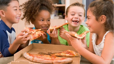 Un groupe d'enfants en train de manger une pizza